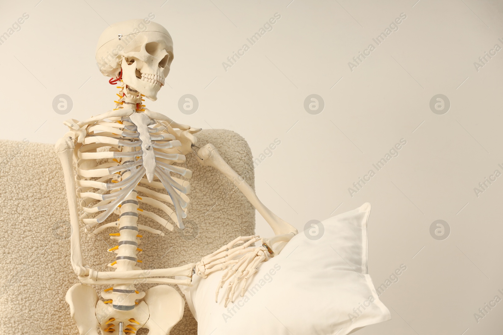 Photo of Waiting concept. Human skeleton sitting in armchair indoors