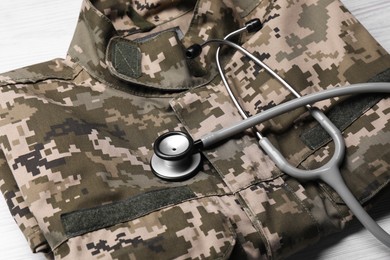 Stethoscope and military uniform on white table