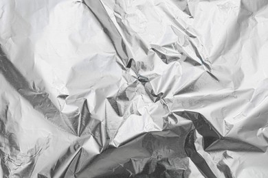 Crumpled silver foil as background, top view
