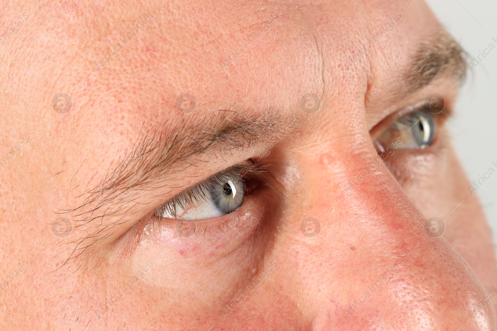 Photo of Man with beautiful blue eyes on light grey background, closeup