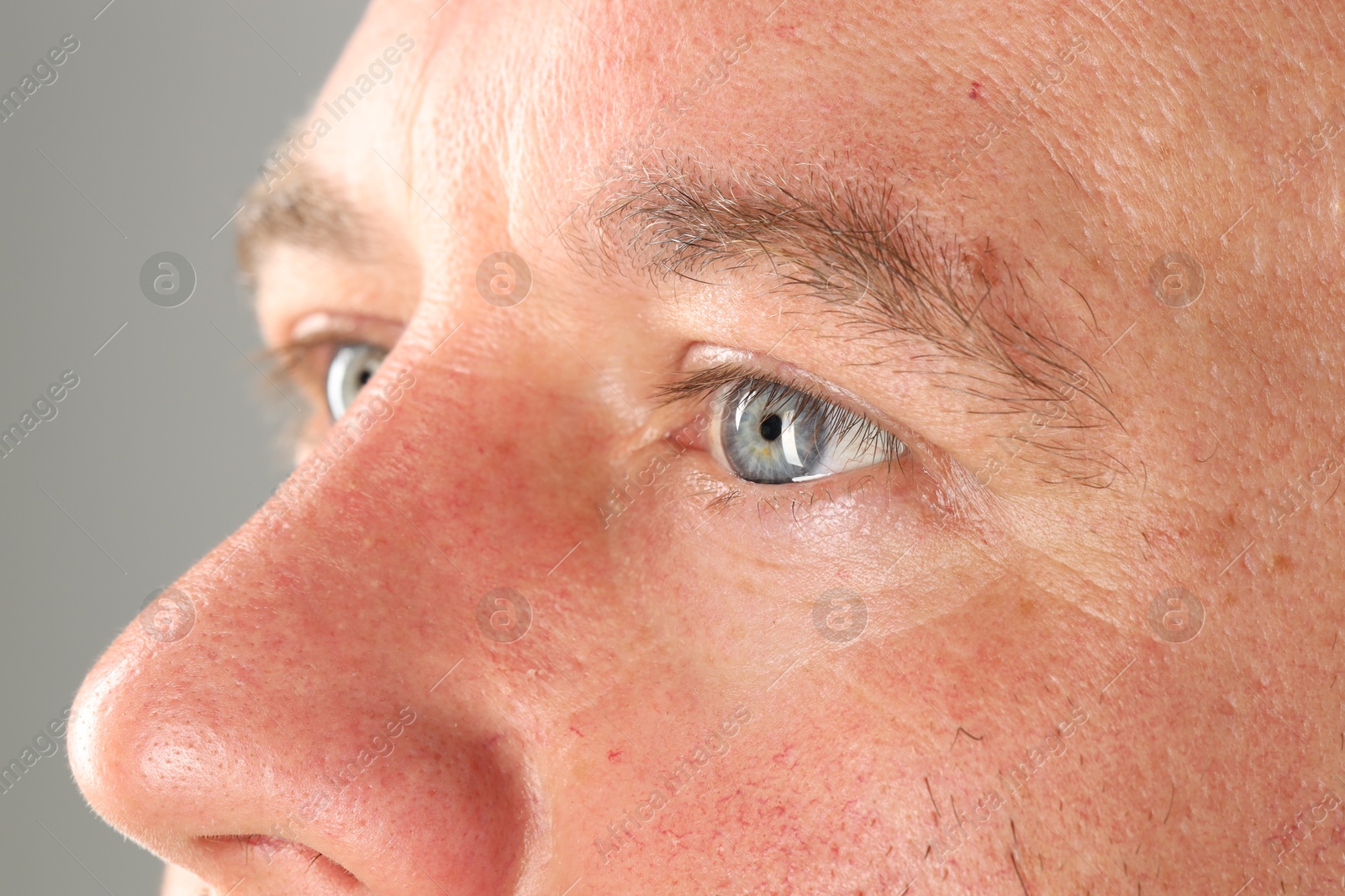 Photo of Man with beautiful blue eyes on light grey background, closeup