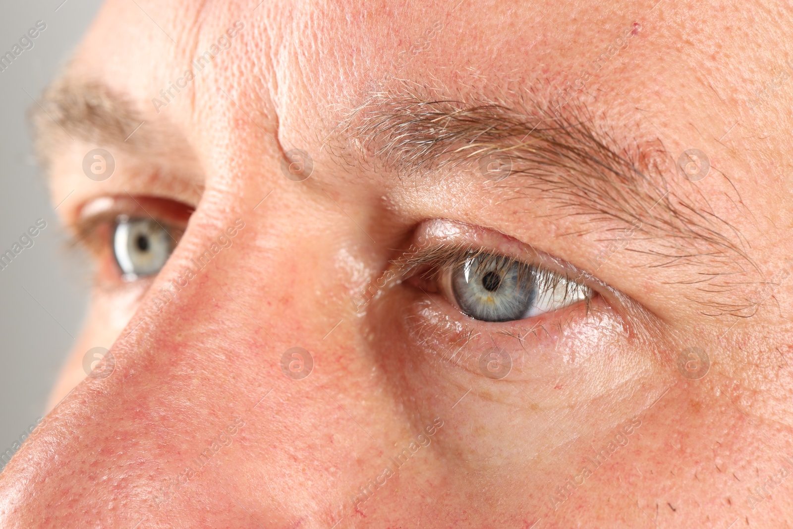 Photo of Man with beautiful blue eyes on light grey background, closeup