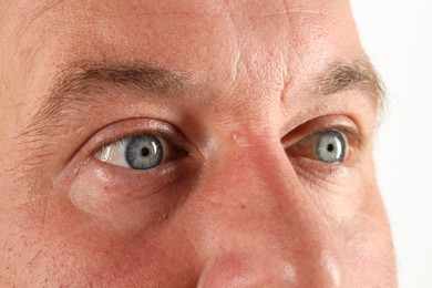 Man with beautiful blue eyes on white background, closeup