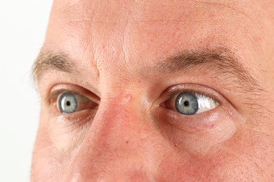 Photo of Man with beautiful blue eyes on white background, closeup