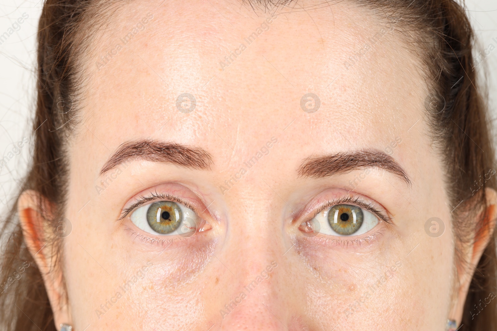 Photo of Woman with beautiful green eyes on light grey background, closeup