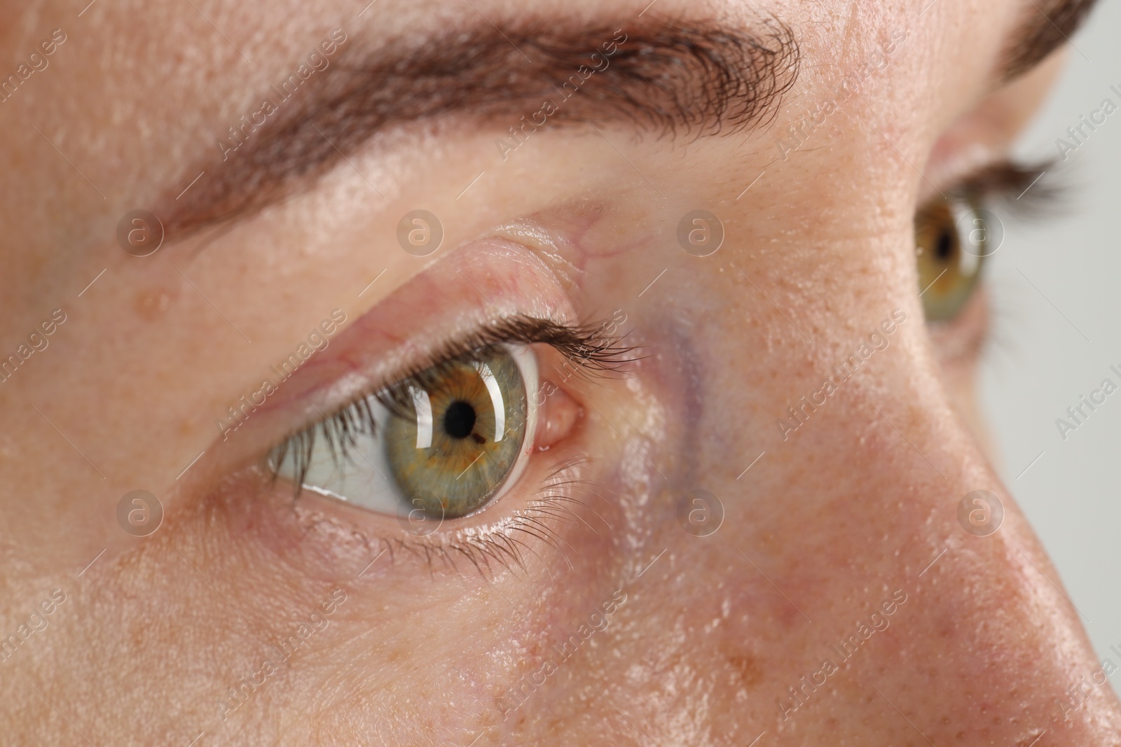 Photo of Woman with beautiful green eyes on light grey background, closeup