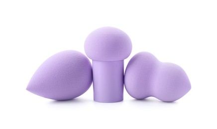 Three violet makeup sponges isolated on white