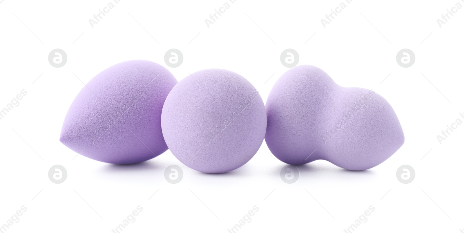 Photo of Three violet makeup sponges isolated on white