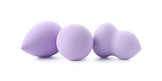 Three violet makeup sponges isolated on white