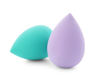 Photo of Turquoise and violet makeup sponges isolated on white