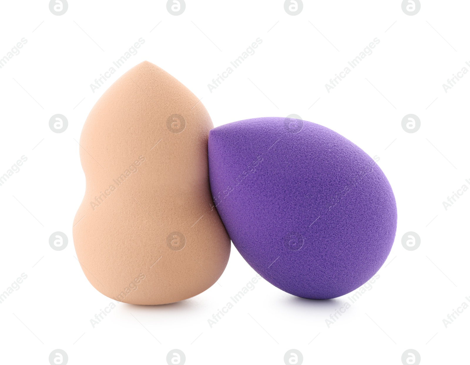 Photo of Beige and violet makeup sponges isolated on white