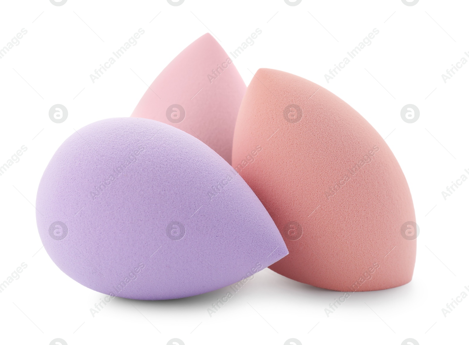 Photo of Violet and beige makeup sponges isolated on white