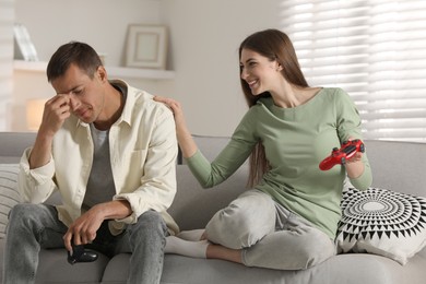 Photo of Couple playing video games with controllers at home