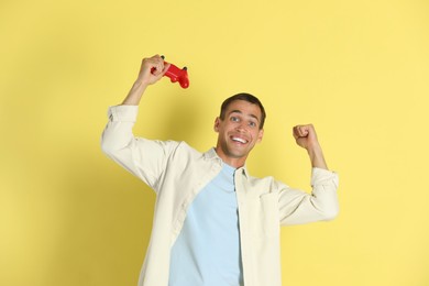 Happy man with controller on yellow background