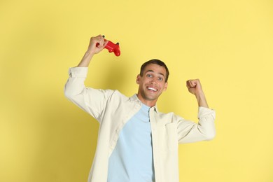 Photo of Happy man with controller on yellow background