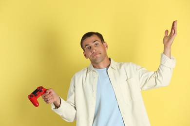 Photo of Unhappy man with controller on yellow background