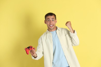 Photo of Happy man with controller on yellow background