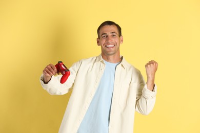 Photo of Happy man with controller on yellow background