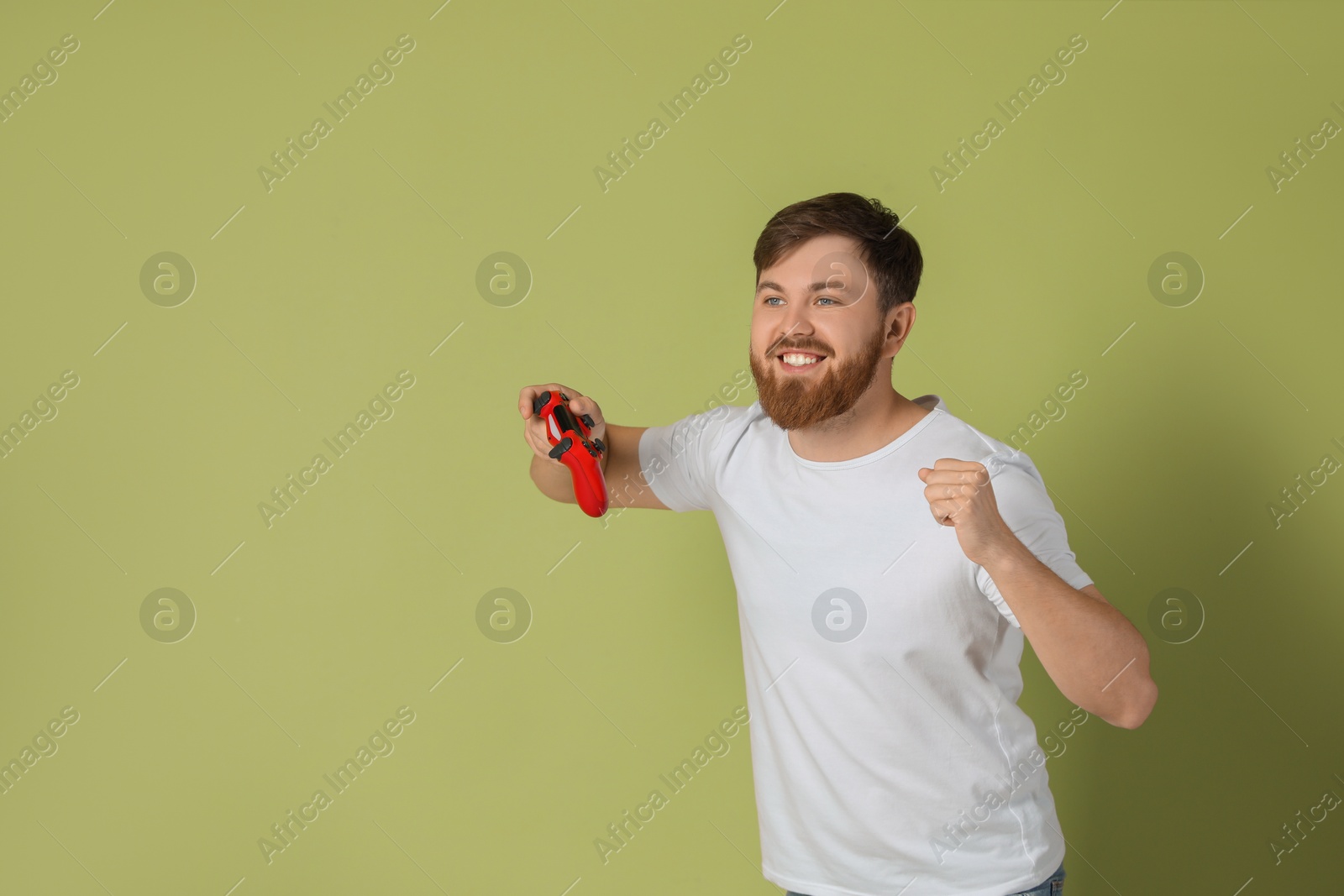 Photo of Happy man with game controller on pale green background. Space for text