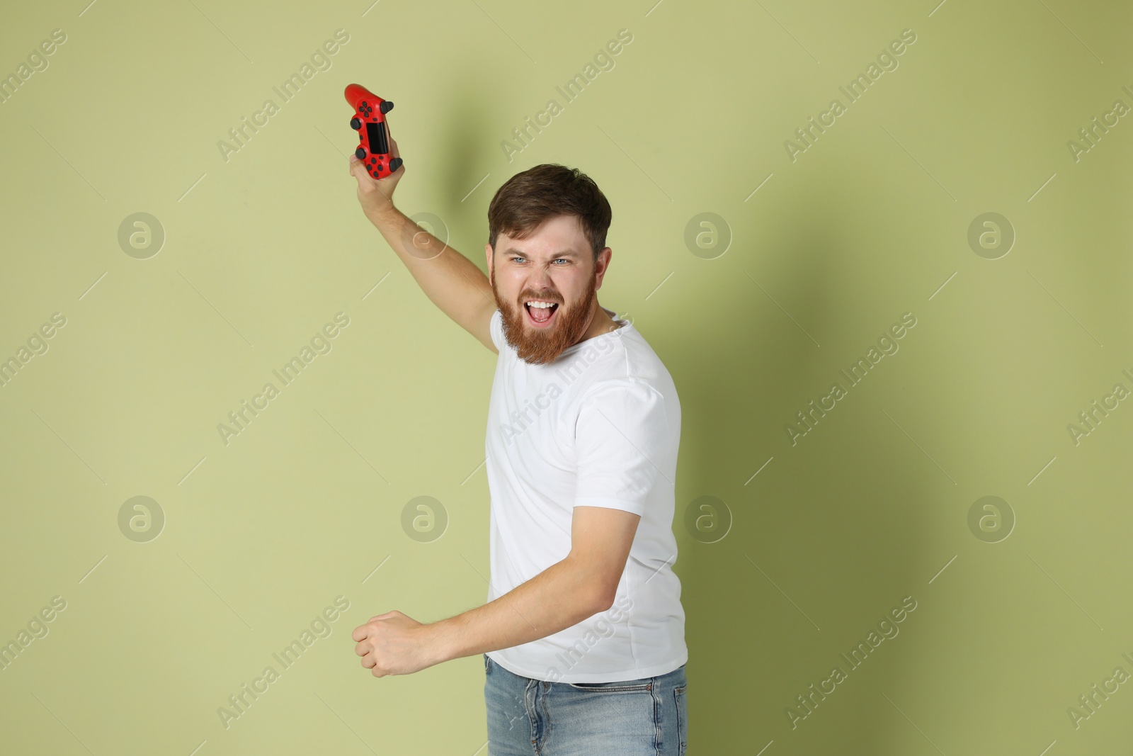 Photo of Emotional man with game controller on pale green background
