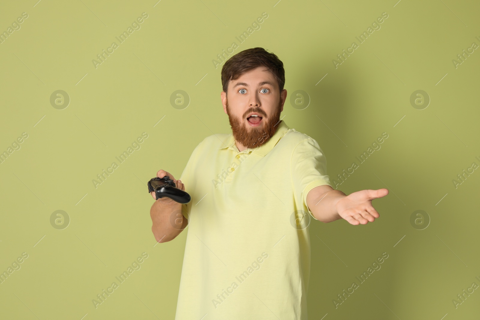 Photo of Emotional man with game controller on pale green background