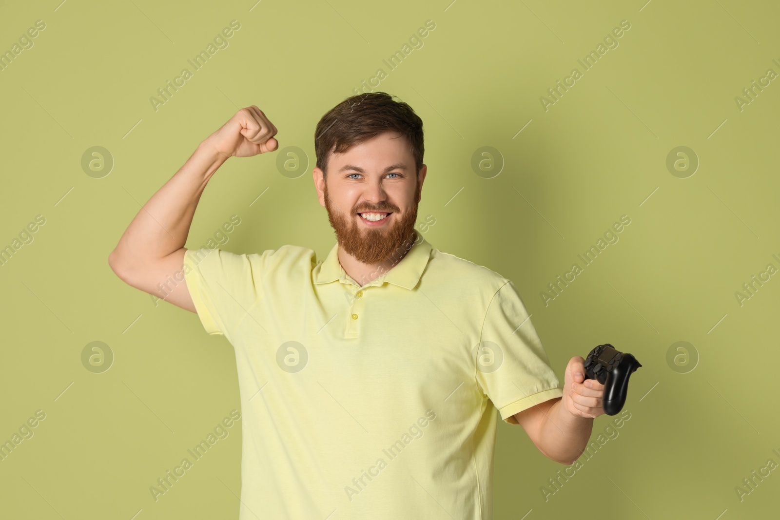 Photo of Emotional man with game controller on pale green background