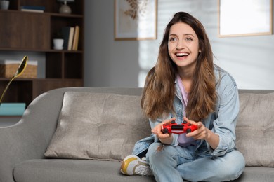 Happy woman playing video game with controller at home