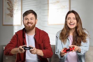 Couple playing video game with controllers at home