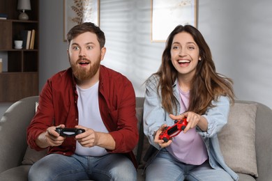 Couple playing video game with controllers at home