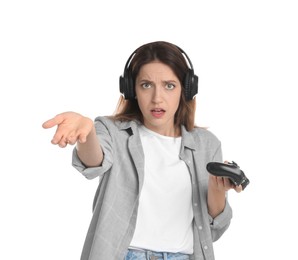 Confused woman in headphones with game controller on white background