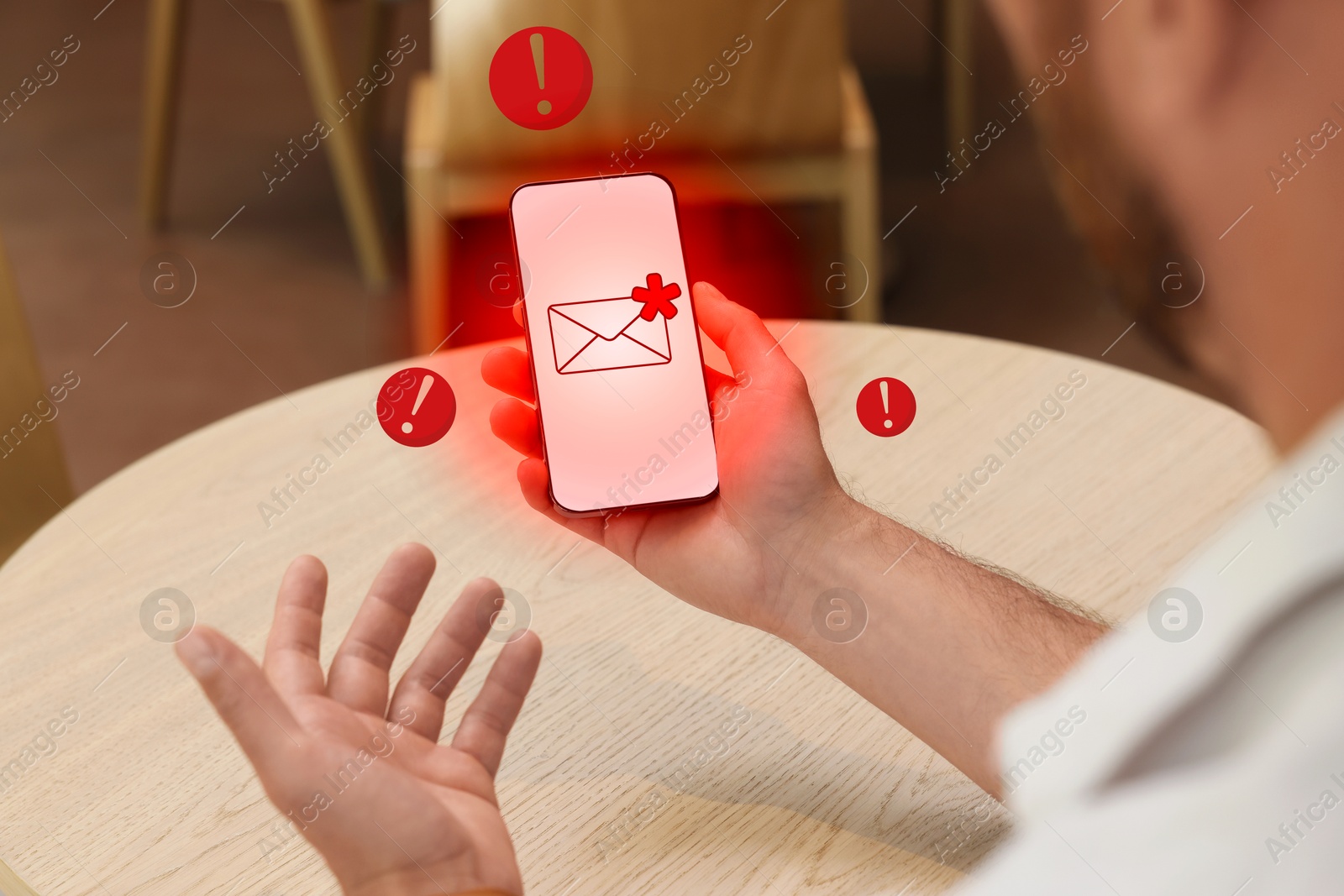 Image of Man using smartphone at table indoors, closeup. Spam message notification on device screen, illustration