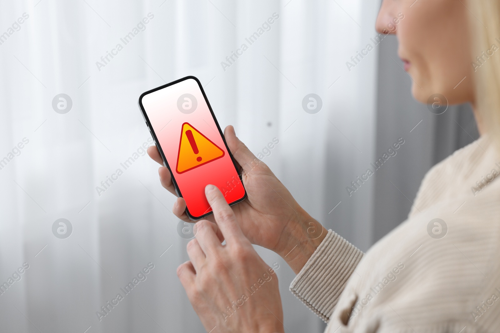 Image of Woman using smartphone indoors, closeup. Warning sign for spam message on device screen
