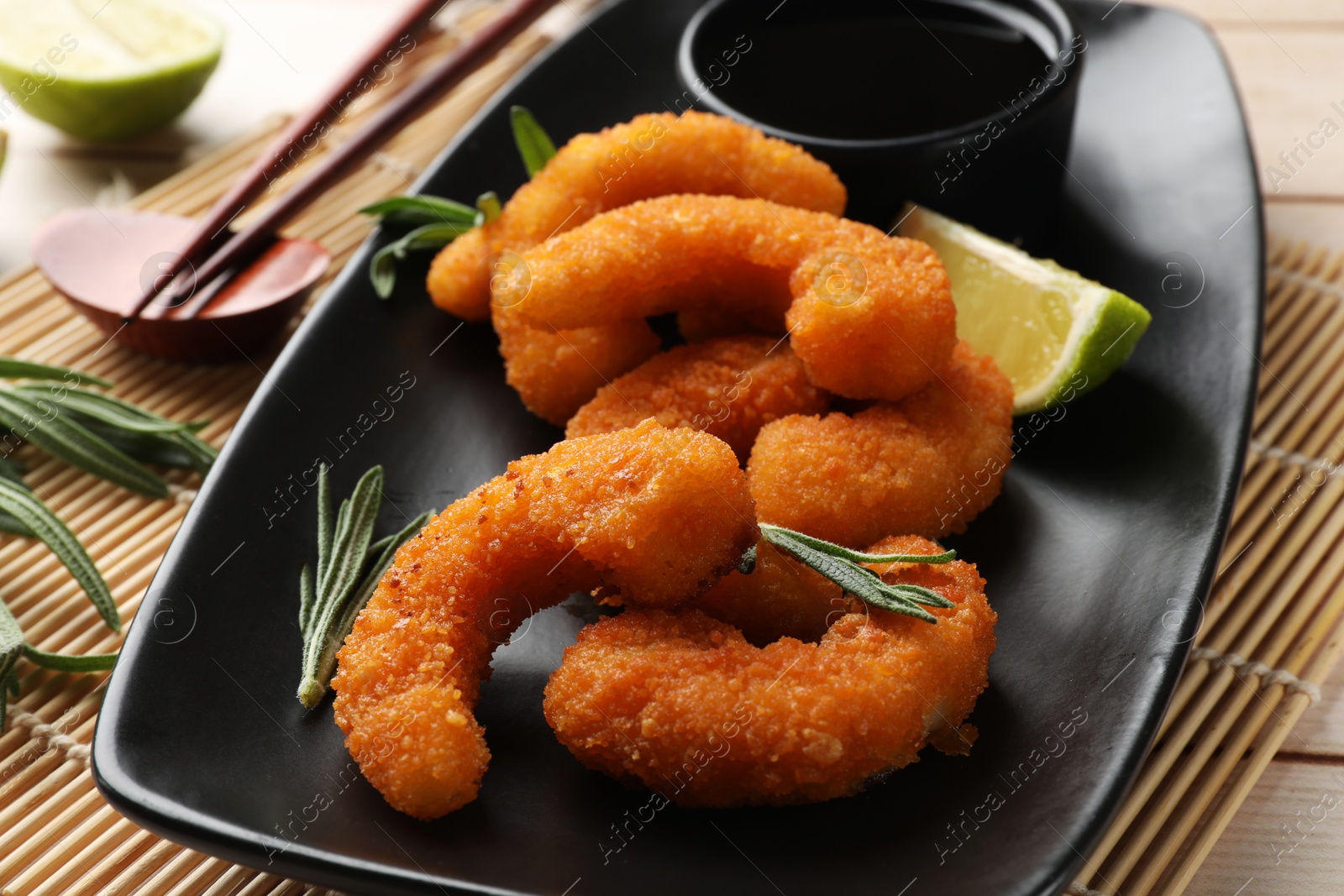 Photo of Tasty breaded fried shrimps served on light wooden table, closeup