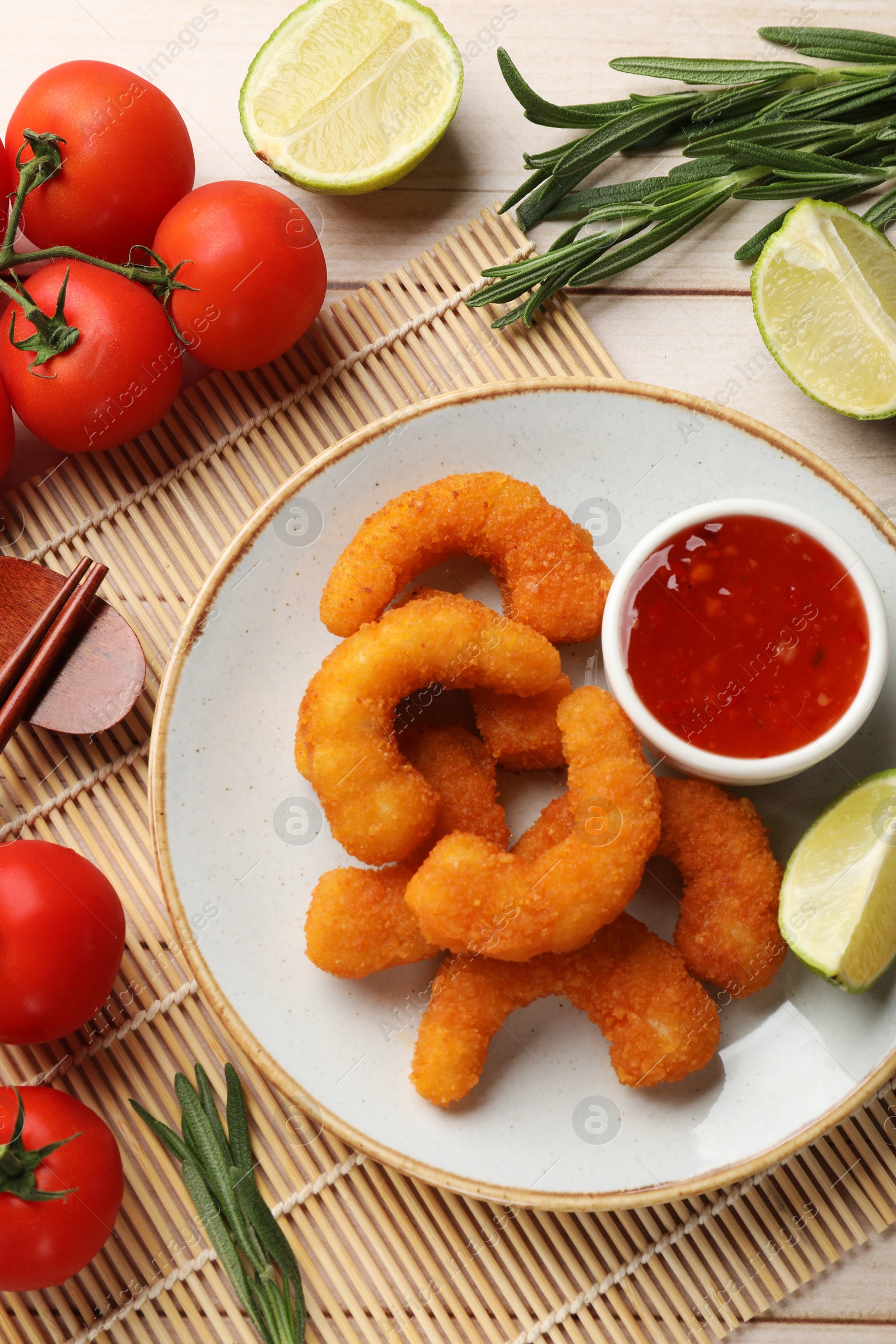 Photo of Tasty breaded fried shrimps served on light wooden table, flat lay