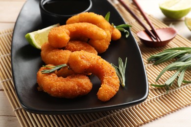 Photo of Tasty breaded fried shrimps served on light wooden table, closeup