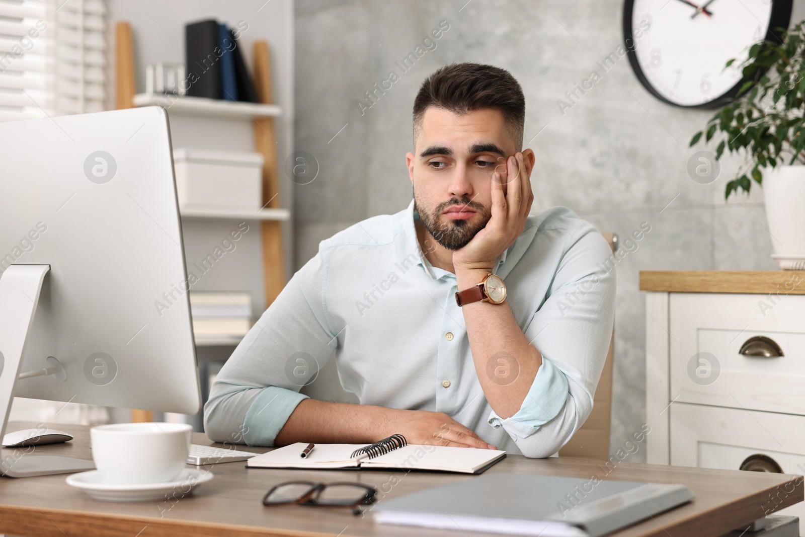 Photo of Overwhelmed man sitting at table in office