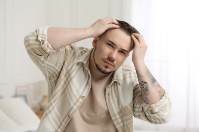 Photo of Baldness concept. Sad man with receding hairline indoors