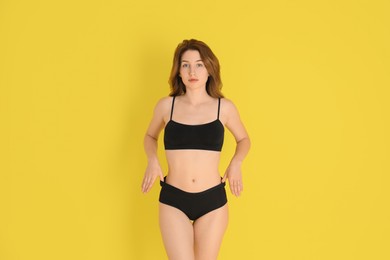 Photo of Woman with slim body posing on yellow background
