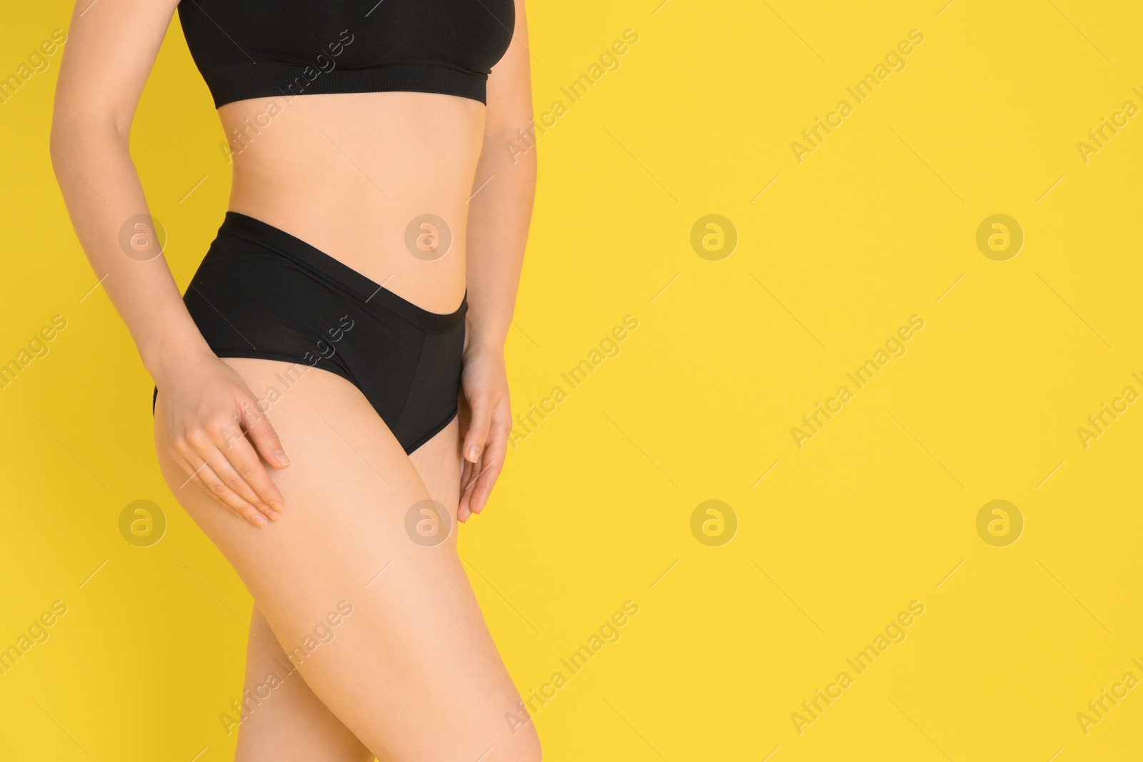 Photo of Woman with slim body posing on yellow background, closeup. Space for text