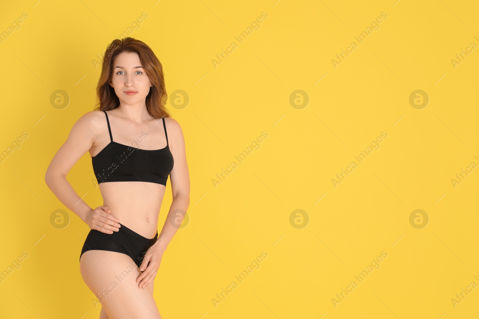 Photo of Woman with slim body posing on yellow background, space for text