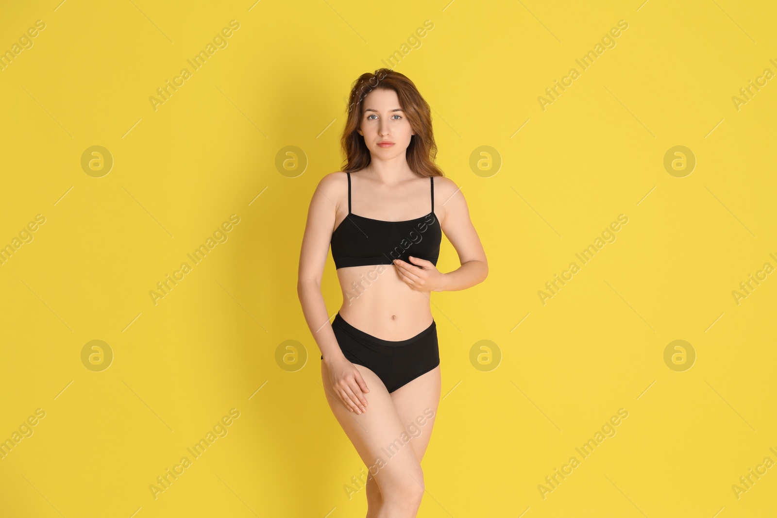 Photo of Woman with slim body posing on yellow background