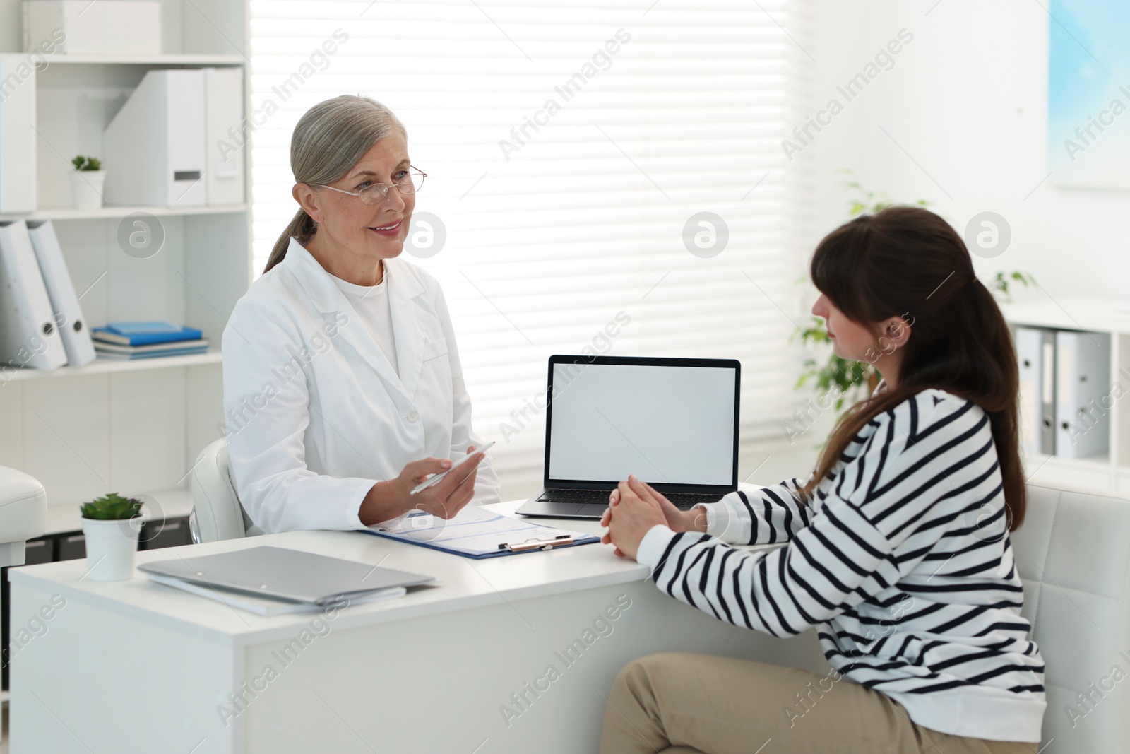 Photo of Lung disease. Doctor showing something on laptop to her patient in clinic