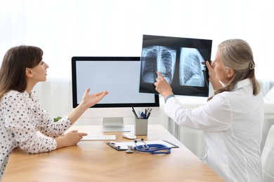 Photo of Lung disease. Doctor showing chest x-ray to her patient in clinic