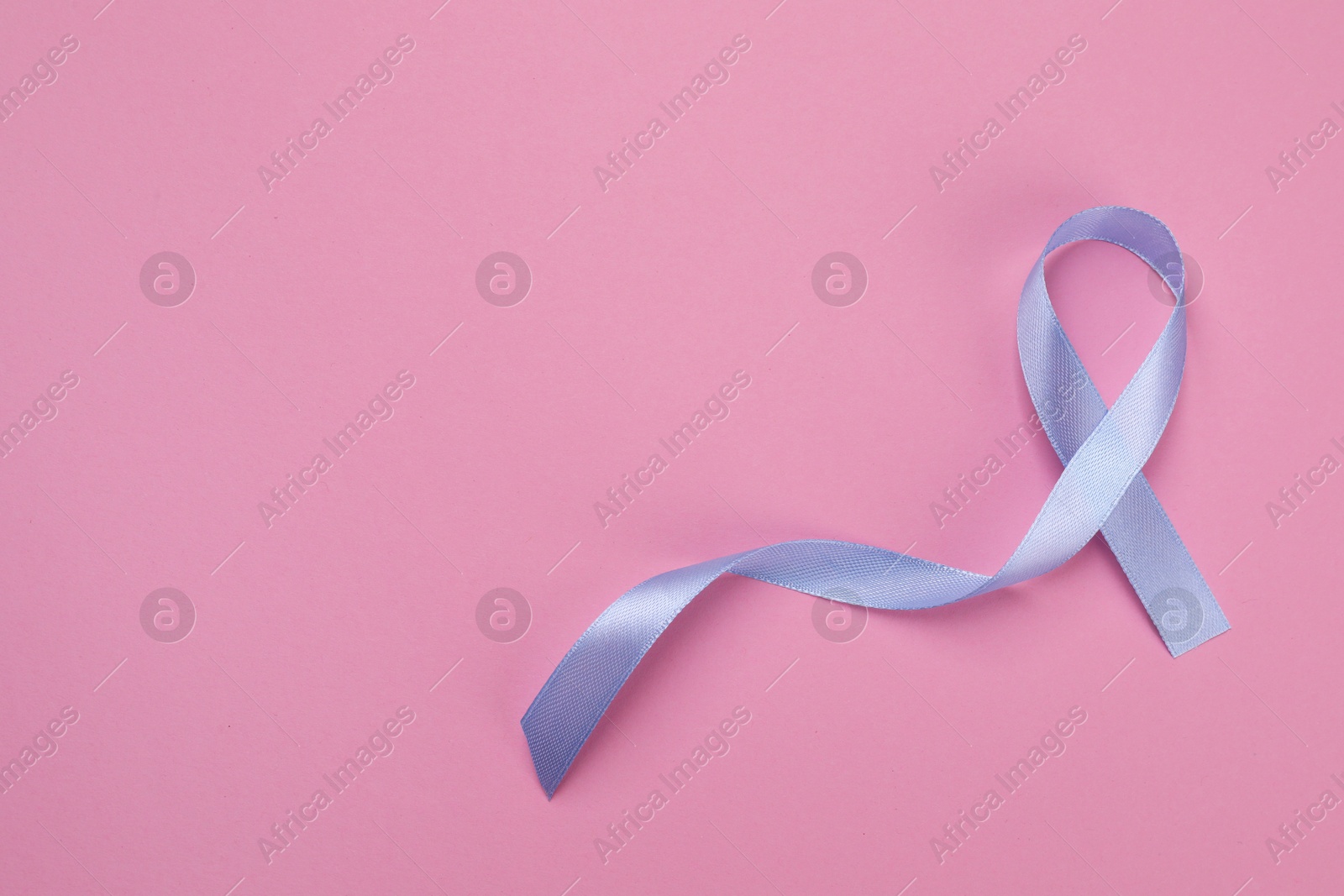 Photo of International Psoriasis Day. Ribbon as symbol of support on pink background, top view. Space for text