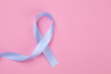 Photo of International Psoriasis Day. Ribbon as symbol of support on pink background, top view. Space for text