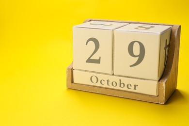 International Psoriasis Day - 29th of October. Block calendar on yellow background, space for text