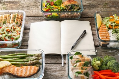 Photo of Healthy meal. Open notebook and containers with different products on wooden table