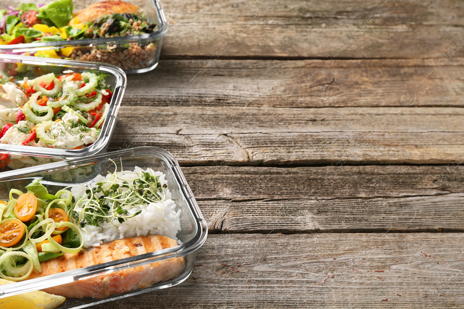 Photo of Healthy meal. Containers with different products on wooden table