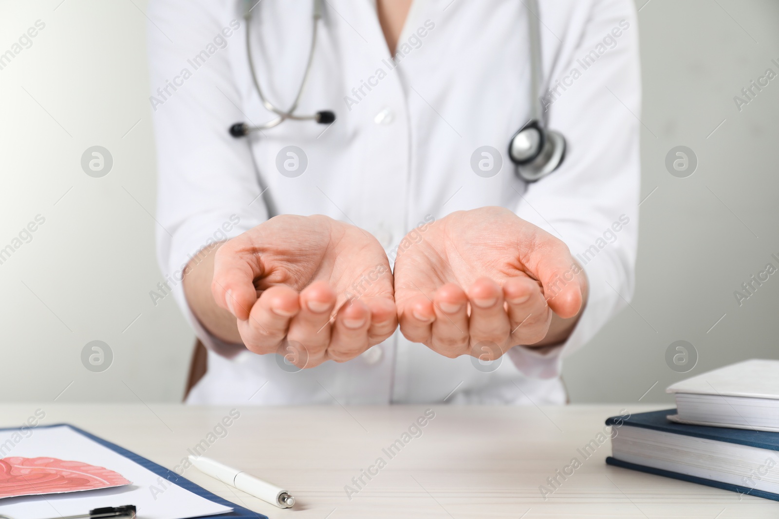 Photo of Doctor holding something at wooden table, closeup