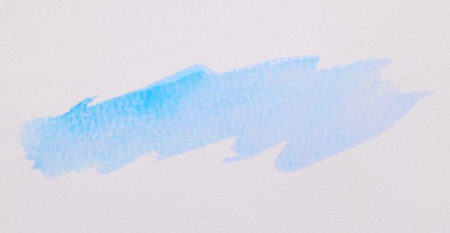 Photo of Blot of blue watercolor paint on white paper, top view